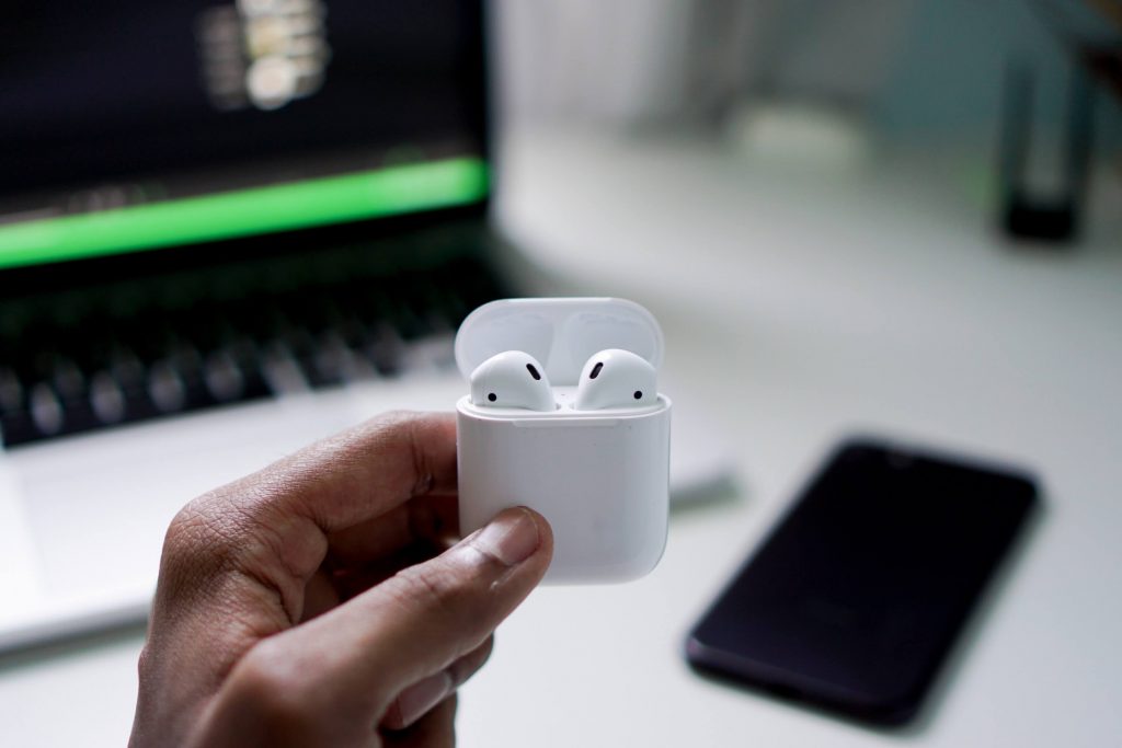 A person holding Apple AirPods case in hands