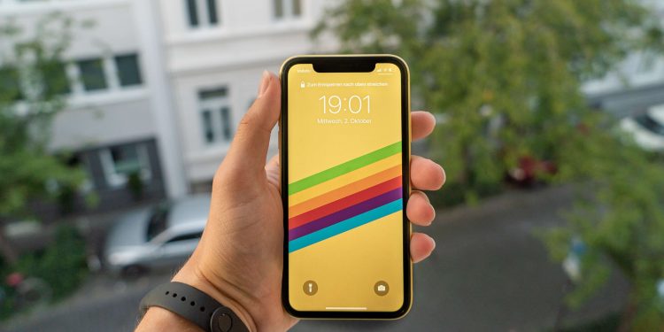 A person holding an iPhone XR in yellow