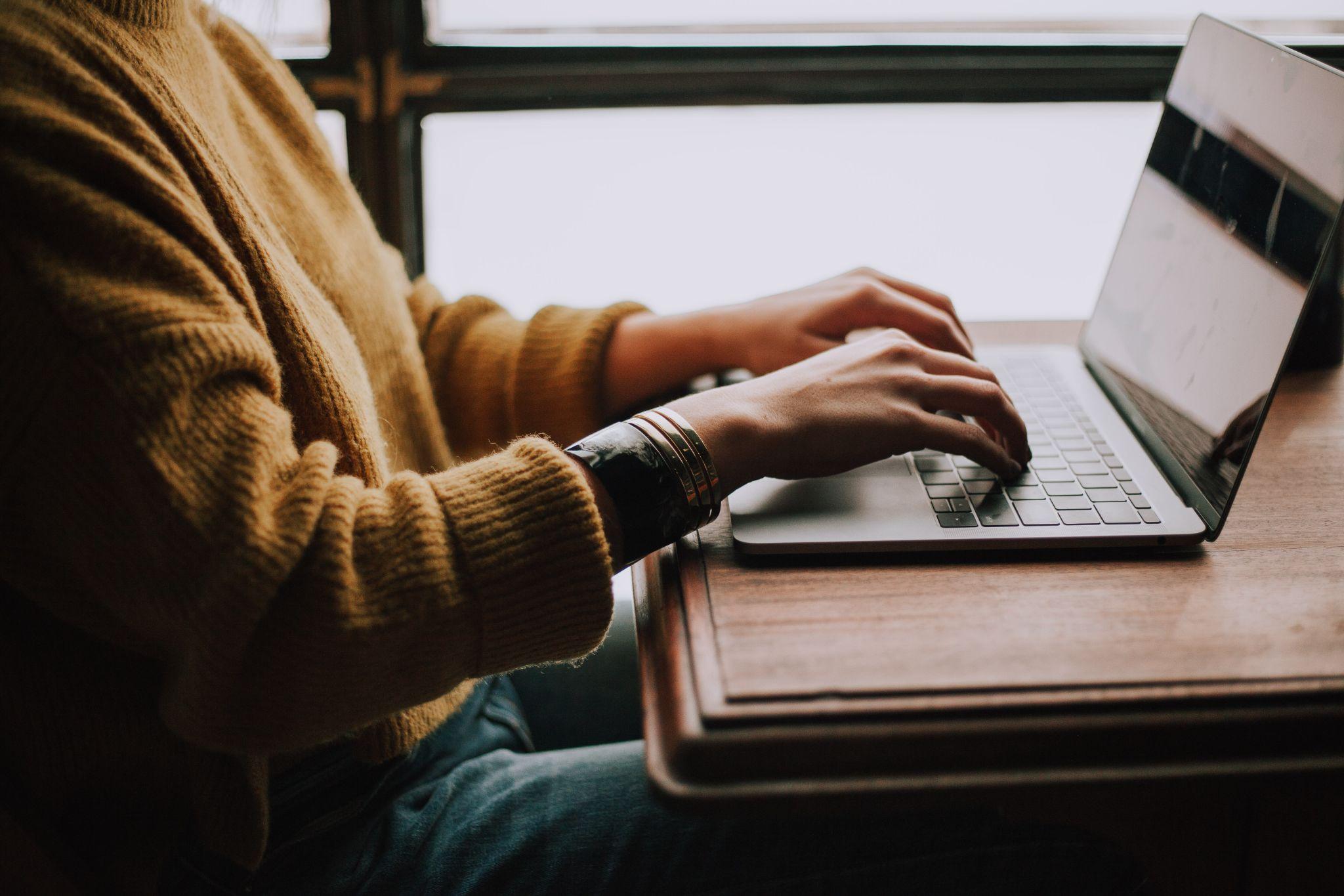 A person typing on a MacBook