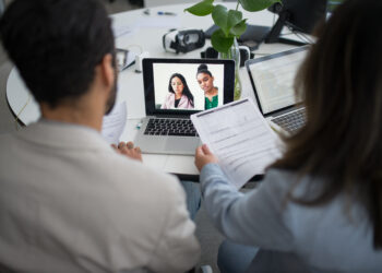 Two personnels from a company interviewing candidates online in a video call