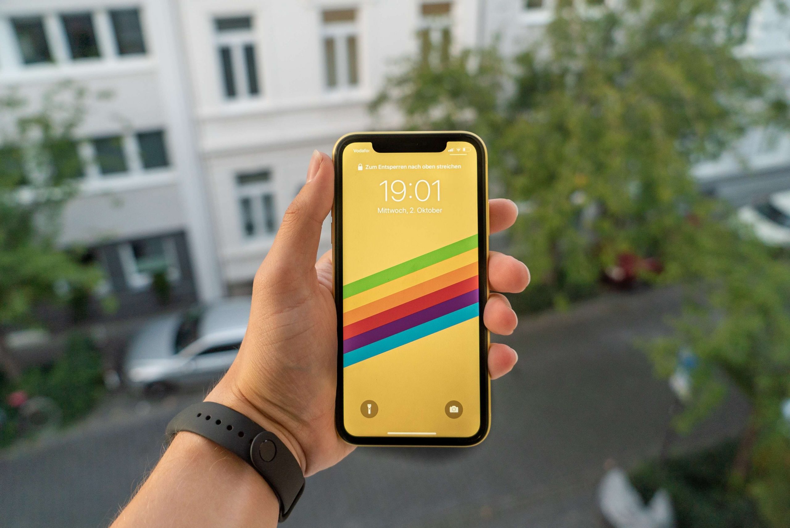 A person holding an iPhone XR in yellow