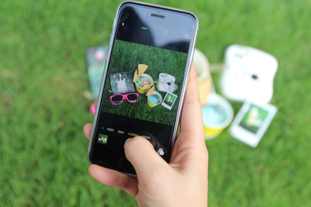 A person shooting video of items on a green grass